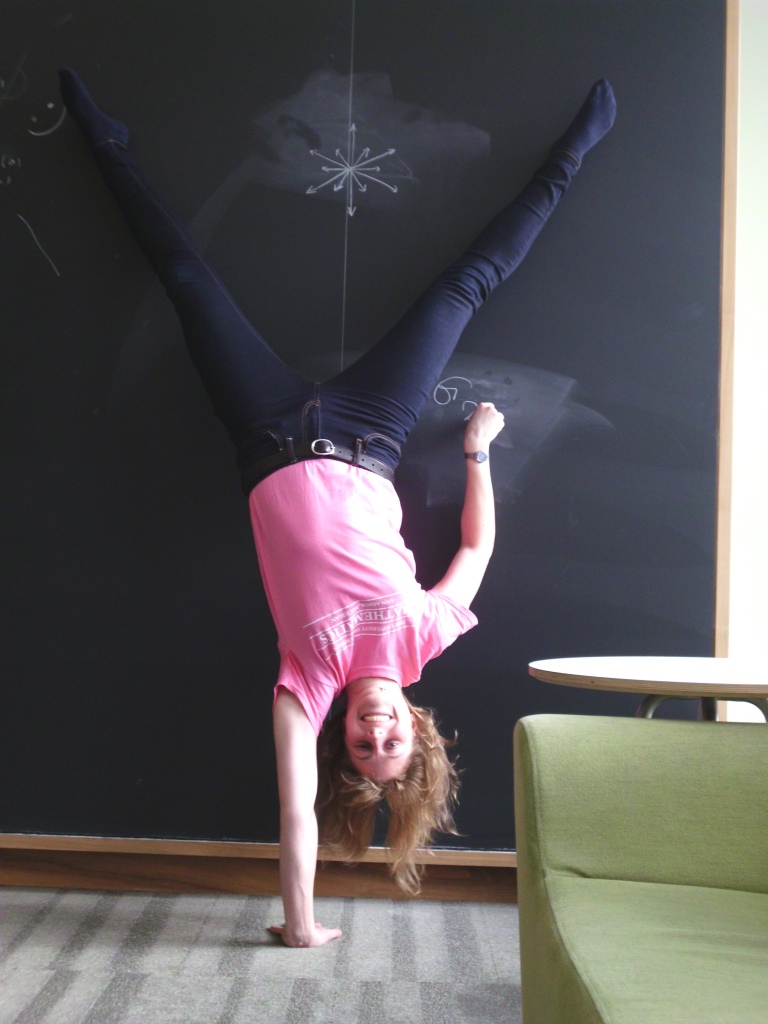 picture of Jessica Fintzen doing a one-arm-handstand in front of the blackboard